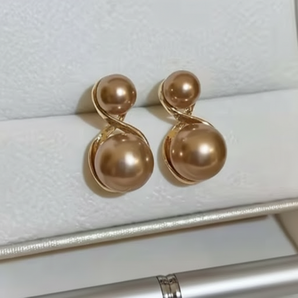 Pair of gold earrings on a white jewelry display box